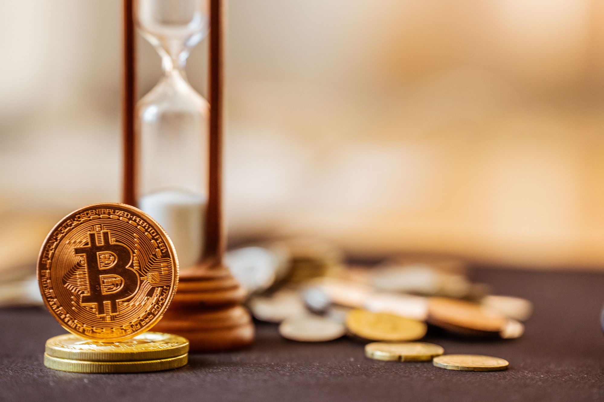 Bitcoins next to an hourglass