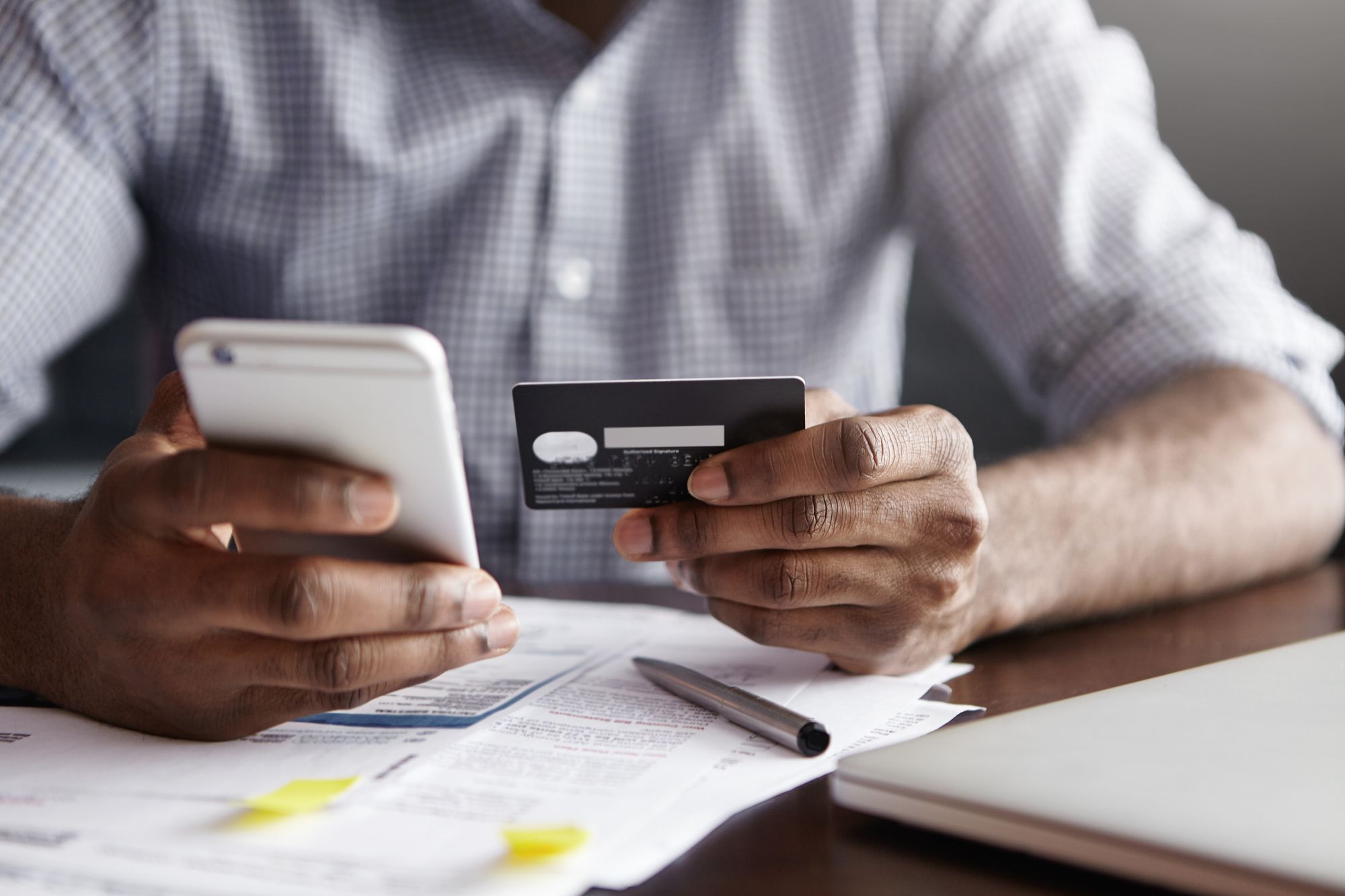 Male hands holding an iphone and a credit card