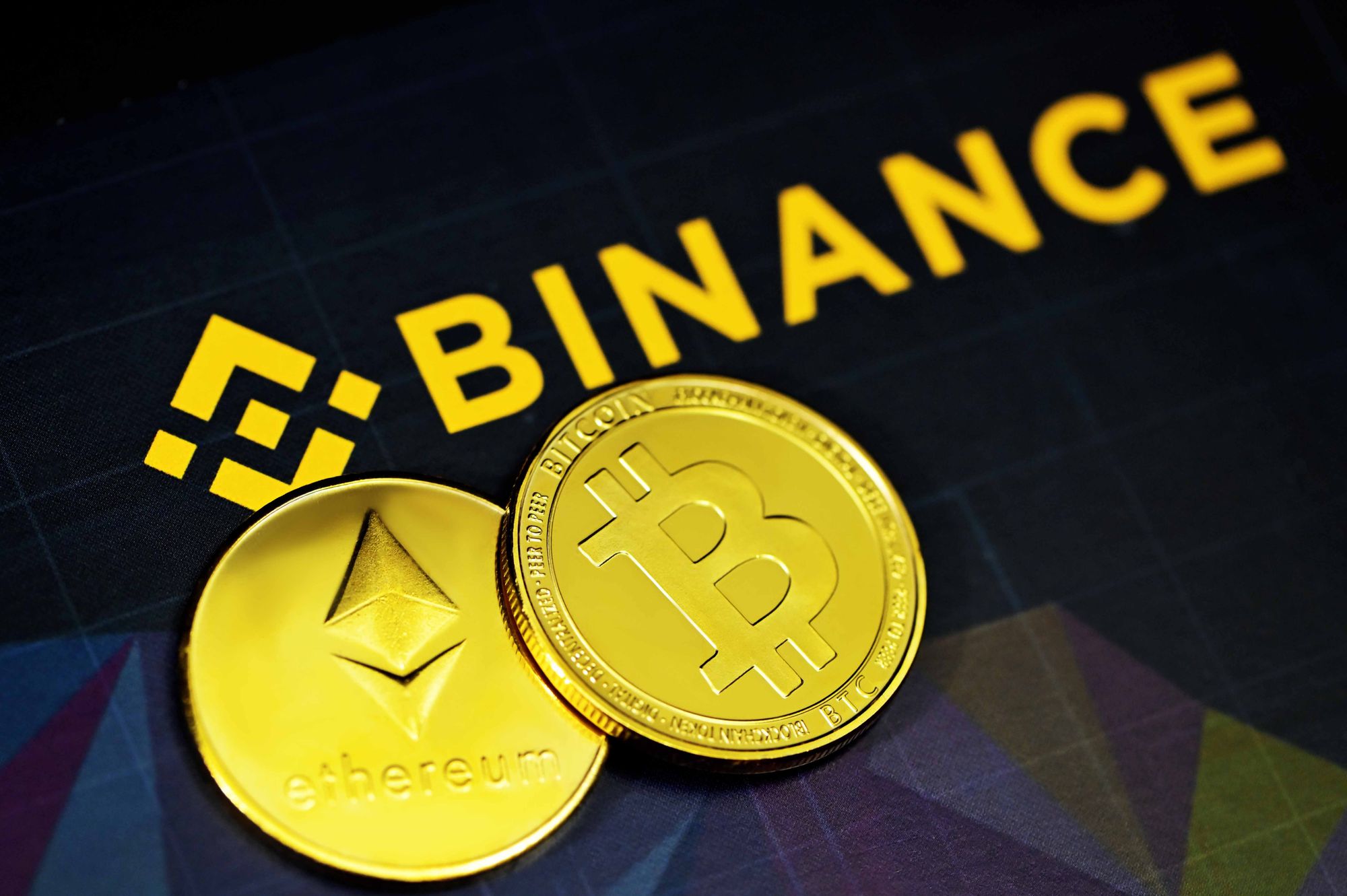Binance logo next to an ethereum and bitcoin